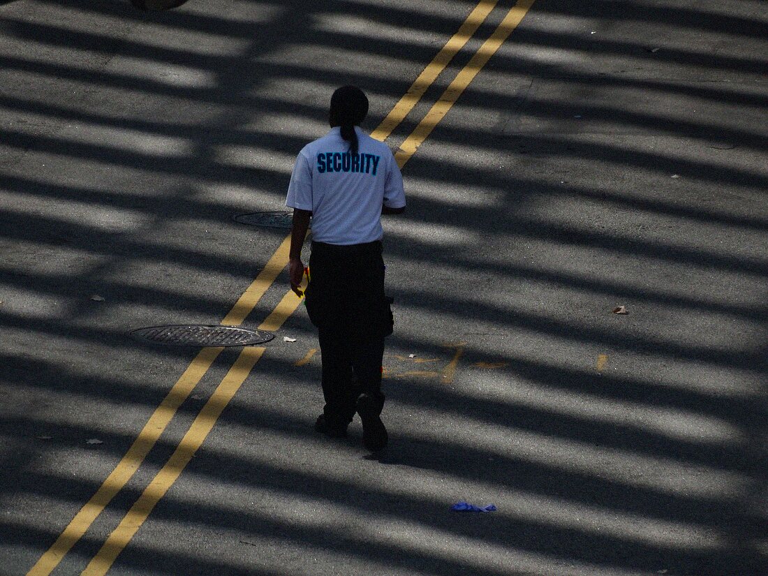Uniformed security officer on foot patrol along an Orlando commercial street
