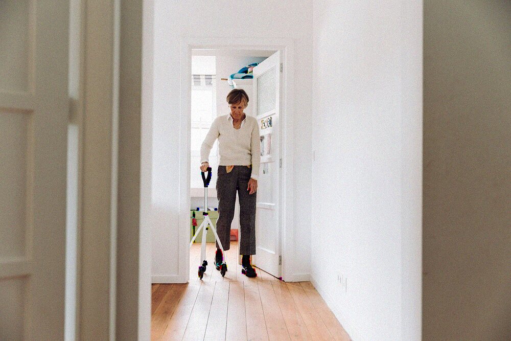 Resident using a rollator in a sunlit hallway at an Orlando senior living community